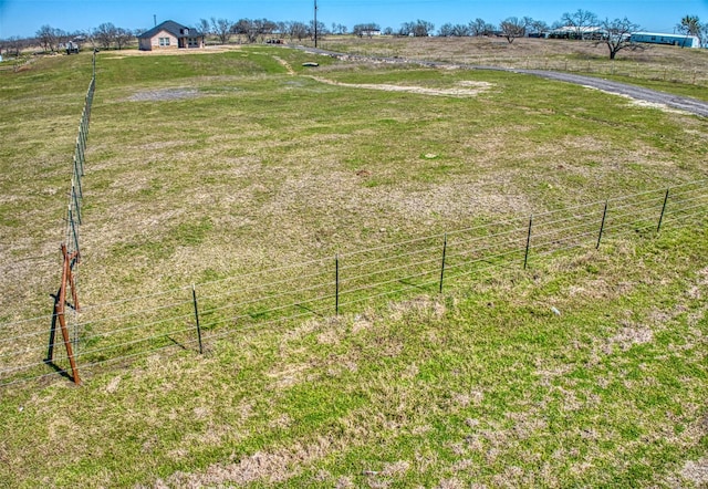 view of yard featuring a rural view and fence