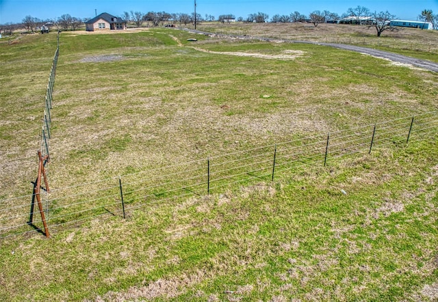 view of yard with a rural view and fence
