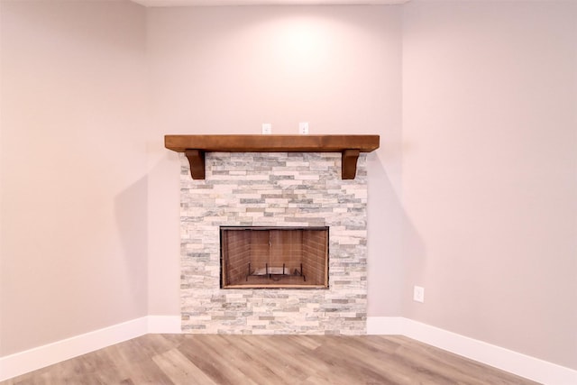 room details with wood finished floors, a fireplace, and baseboards