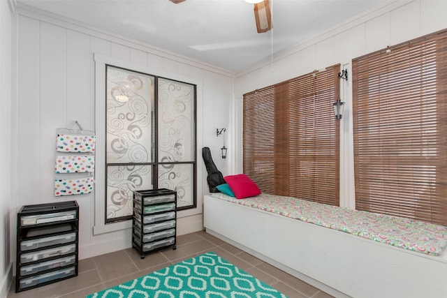 bedroom featuring tile patterned floors, ornamental molding, and a ceiling fan