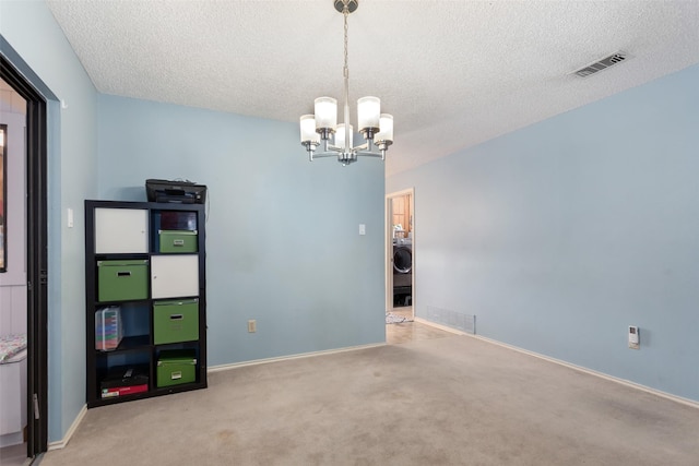 empty room featuring visible vents, carpet, washer / dryer, a notable chandelier, and a textured ceiling