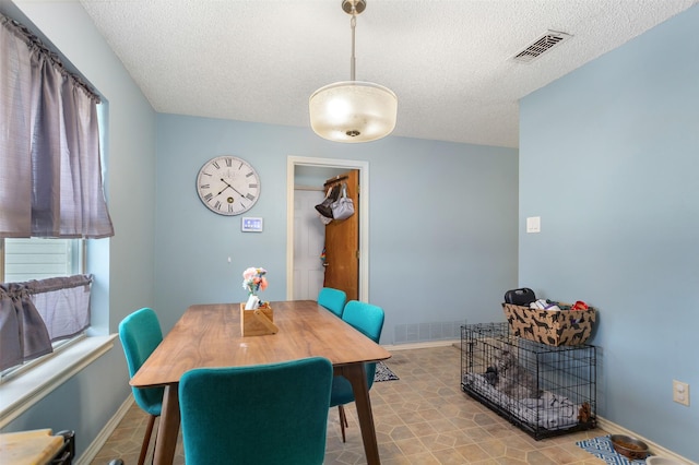 dining room with visible vents, baseboards, and a textured ceiling