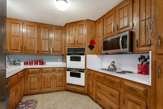 kitchen featuring brown cabinets, appliances with stainless steel finishes, and light countertops