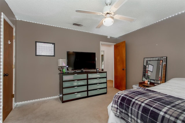 carpeted bedroom with baseboards, a ceiling fan, visible vents, and a textured ceiling