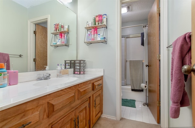 bathroom with enclosed tub / shower combo, a textured ceiling, vanity, and tile patterned flooring