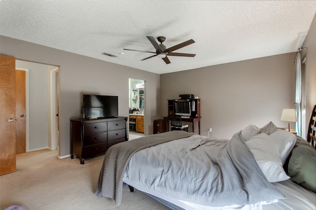 bedroom with visible vents, light colored carpet, ceiling fan, and a textured ceiling