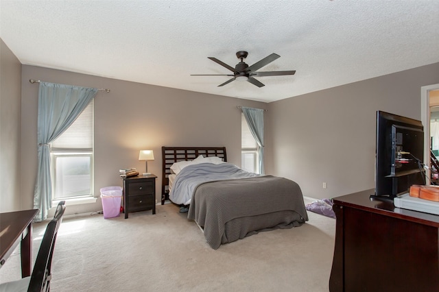 bedroom featuring carpet, a ceiling fan, and a textured ceiling