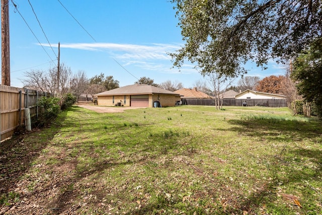 view of yard featuring a detached garage and fence private yard