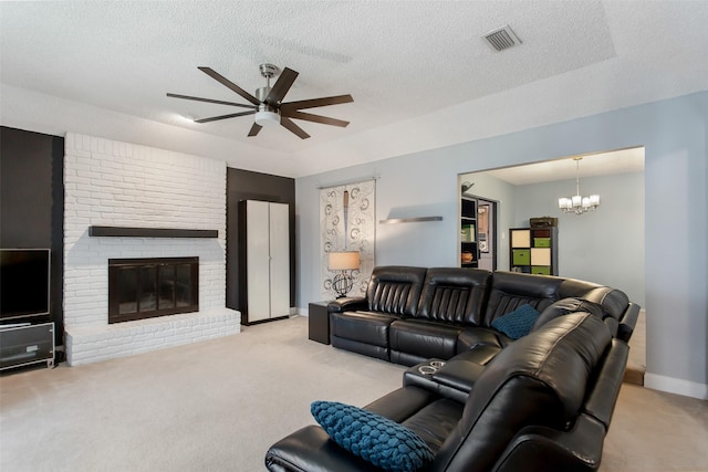 living area featuring baseboards, light carpet, a textured ceiling, a brick fireplace, and ceiling fan with notable chandelier