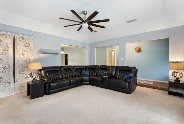 living room with a textured ceiling, carpet flooring, visible vents, and ceiling fan