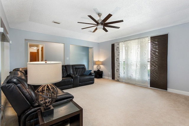 carpeted living area featuring ceiling fan, baseboards, visible vents, and a textured ceiling