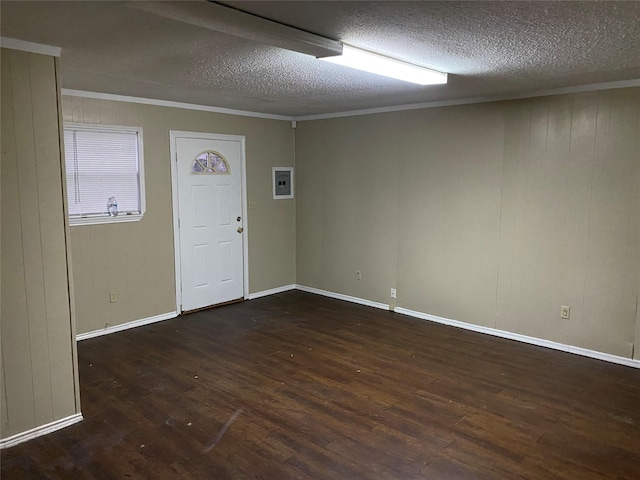 unfurnished room featuring a textured ceiling, wood finished floors, and crown molding