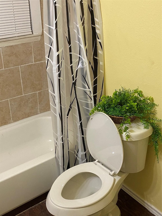 full bath featuring shower / bath combo with shower curtain and toilet