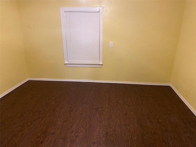 empty room featuring baseboards and wood finished floors