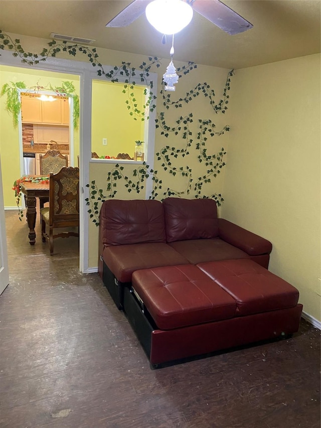 living area with visible vents, baseboards, and ceiling fan