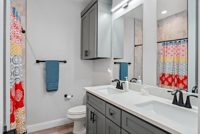 bathroom featuring a sink, a shower with curtain, baseboards, and toilet