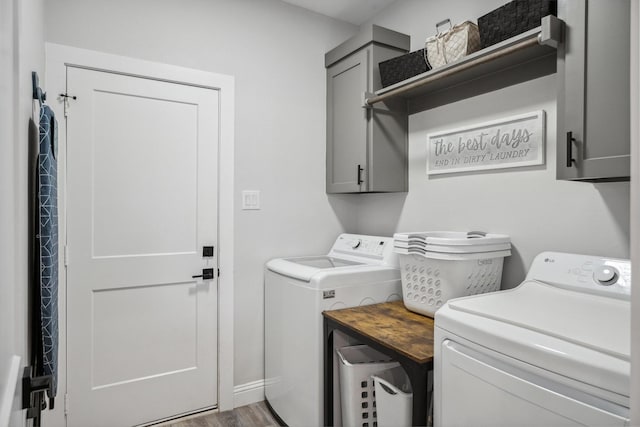 laundry room with cabinet space, wood finished floors, and separate washer and dryer