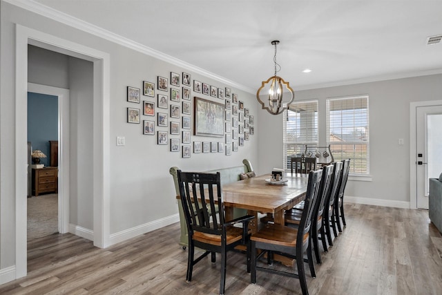 dining space featuring crown molding, baseboards, and wood finished floors