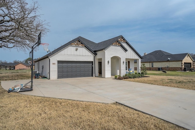 view of front facade featuring a front yard, an attached garage, brick siding, and board and batten siding