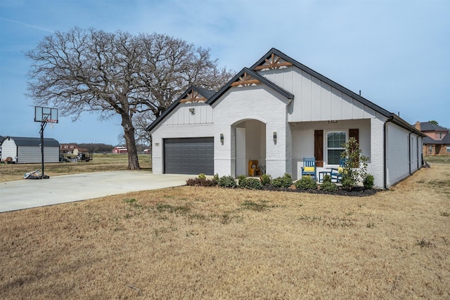 modern inspired farmhouse with brick siding, board and batten siding, concrete driveway, and a front yard