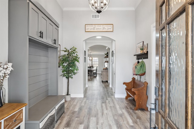 mudroom with arched walkways, visible vents, a chandelier, and crown molding