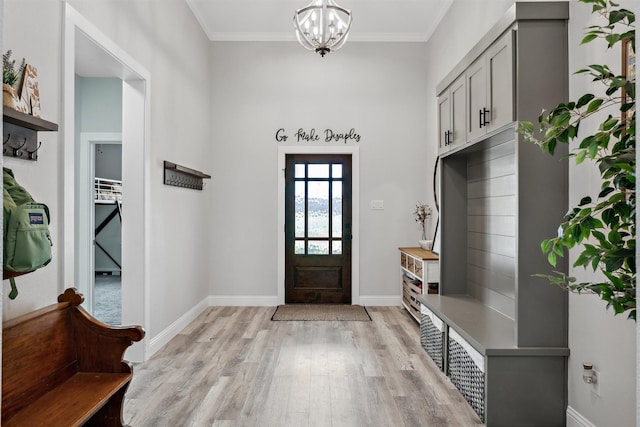 mudroom with an inviting chandelier, light wood-type flooring, baseboards, and ornamental molding