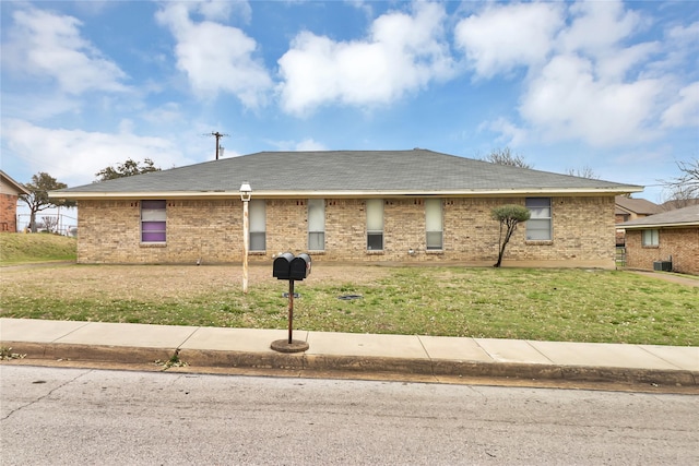 single story home with brick siding and a front yard