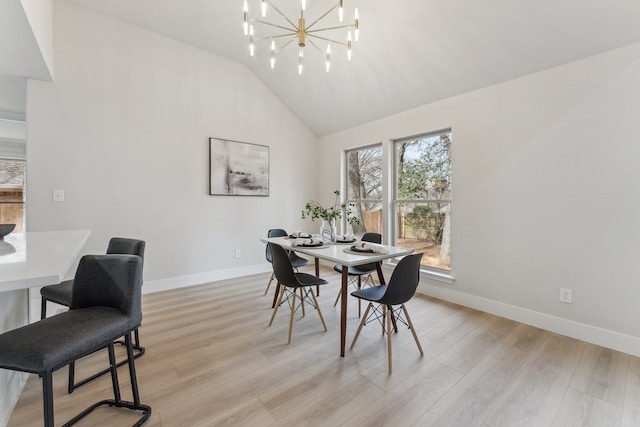 dining room with light wood-type flooring, baseboards, high vaulted ceiling, and an inviting chandelier