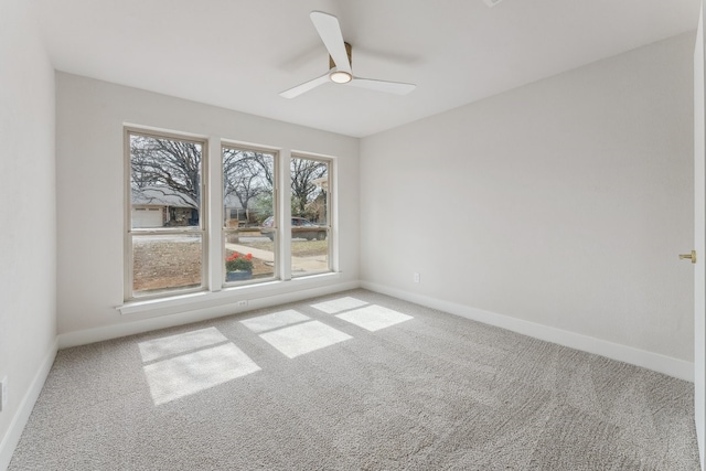 empty room with carpet flooring, ceiling fan, and baseboards