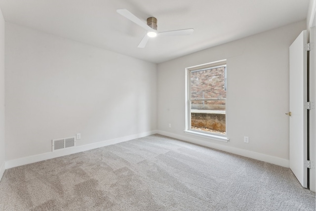 carpeted spare room featuring visible vents, baseboards, and ceiling fan