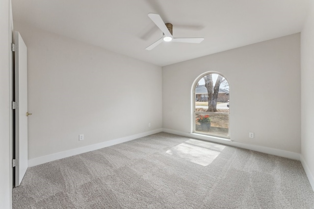 spare room with baseboards, carpet, and a ceiling fan