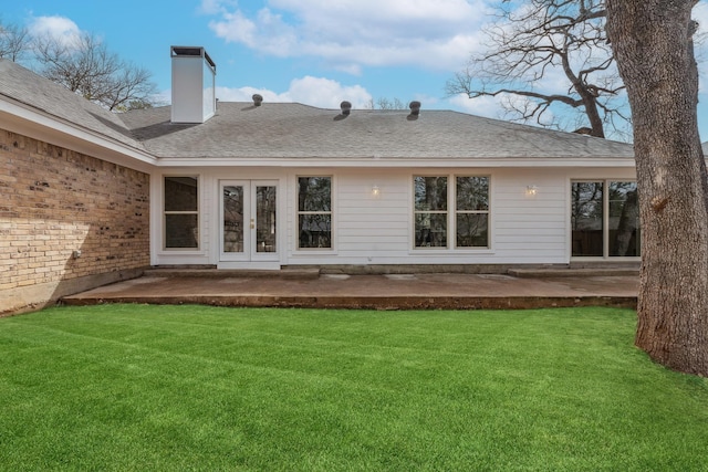 back of property featuring a patio, french doors, a lawn, and a chimney