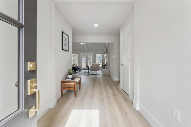 hall featuring recessed lighting, light wood-type flooring, and baseboards