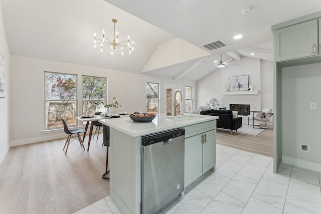 kitchen featuring vaulted ceiling with beams, a fireplace, a sink, stainless steel dishwasher, and a wealth of natural light