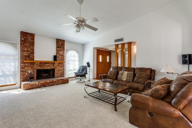 carpeted living area with visible vents, lofted ceiling, ceiling fan, and a fireplace