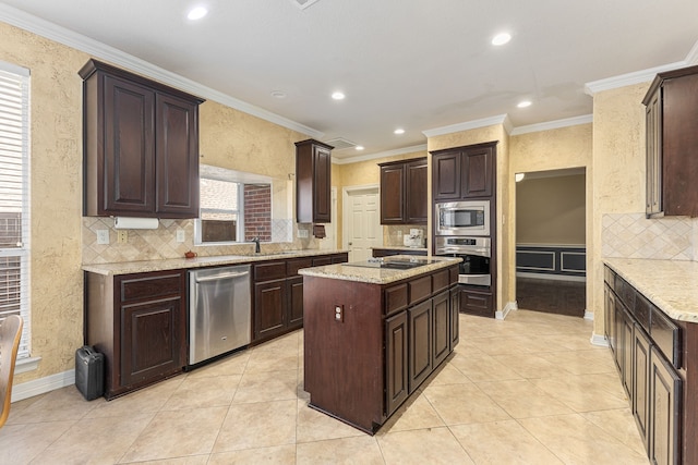 kitchen with recessed lighting, dark brown cabinetry, appliances with stainless steel finishes, crown molding, and a center island