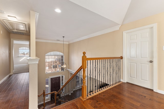 stairway with baseboards, attic access, ornamental molding, hardwood / wood-style floors, and an inviting chandelier