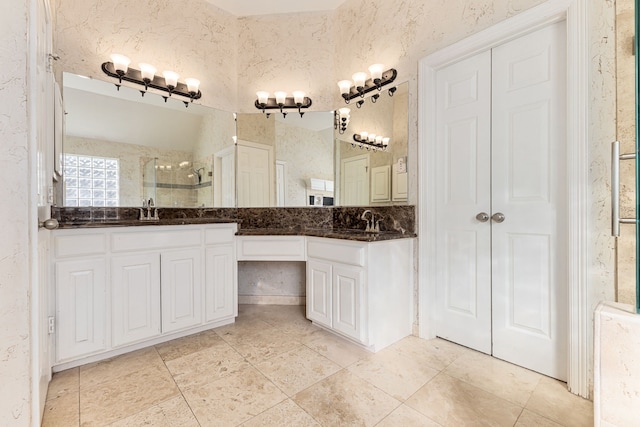 bathroom with double vanity, a stall shower, and a sink