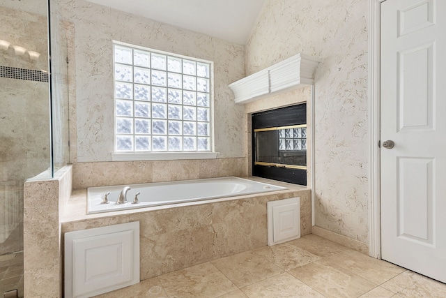 full bath featuring lofted ceiling, a bath, a tile shower, and wallpapered walls