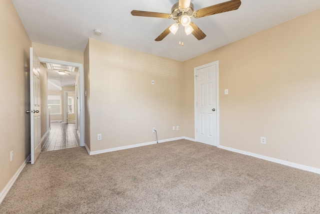 unfurnished bedroom featuring attic access, a ceiling fan, baseboards, and carpet floors