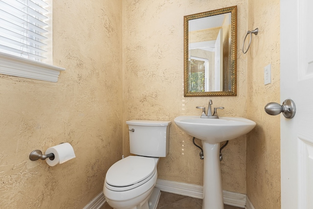 bathroom with tile patterned floors, toilet, and baseboards