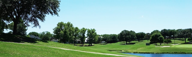 view of property's community featuring golf course view, a yard, and a water view