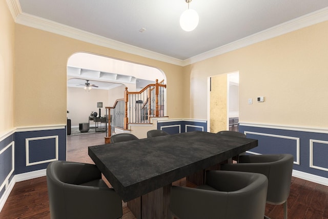 dining space featuring stairs, arched walkways, dark wood finished floors, and wainscoting