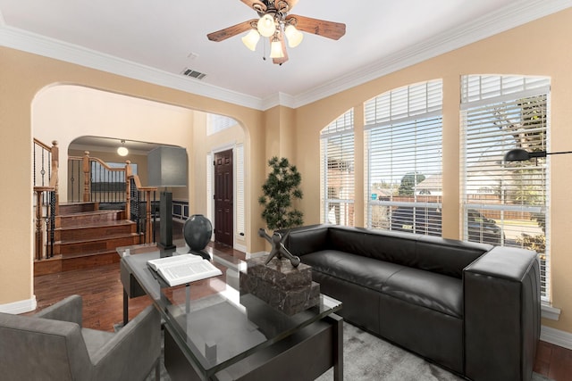 living room featuring visible vents, stairway, ornamental molding, wood finished floors, and arched walkways