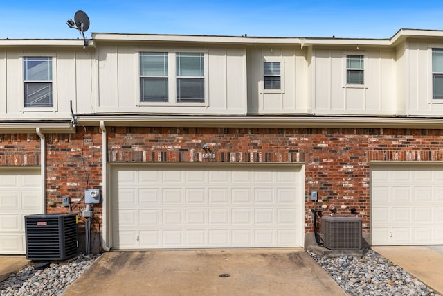 garage with central AC unit and driveway