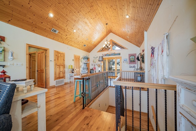 hallway with wooden ceiling, an upstairs landing, visible vents, and wood-type flooring