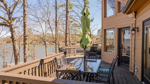 wooden deck featuring outdoor dining area and a water view