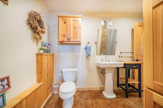 half bathroom with baseboards and toilet