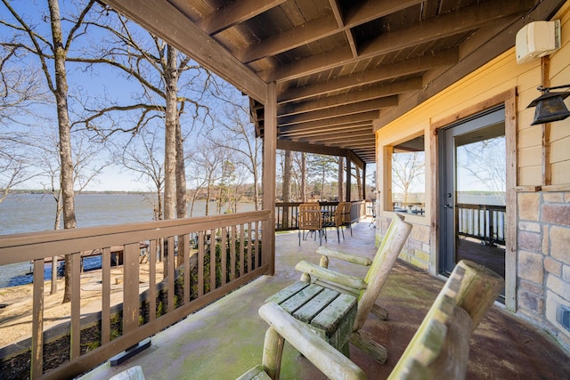 deck with outdoor dining area and a water view