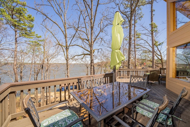 wooden terrace with outdoor dining area and a water view